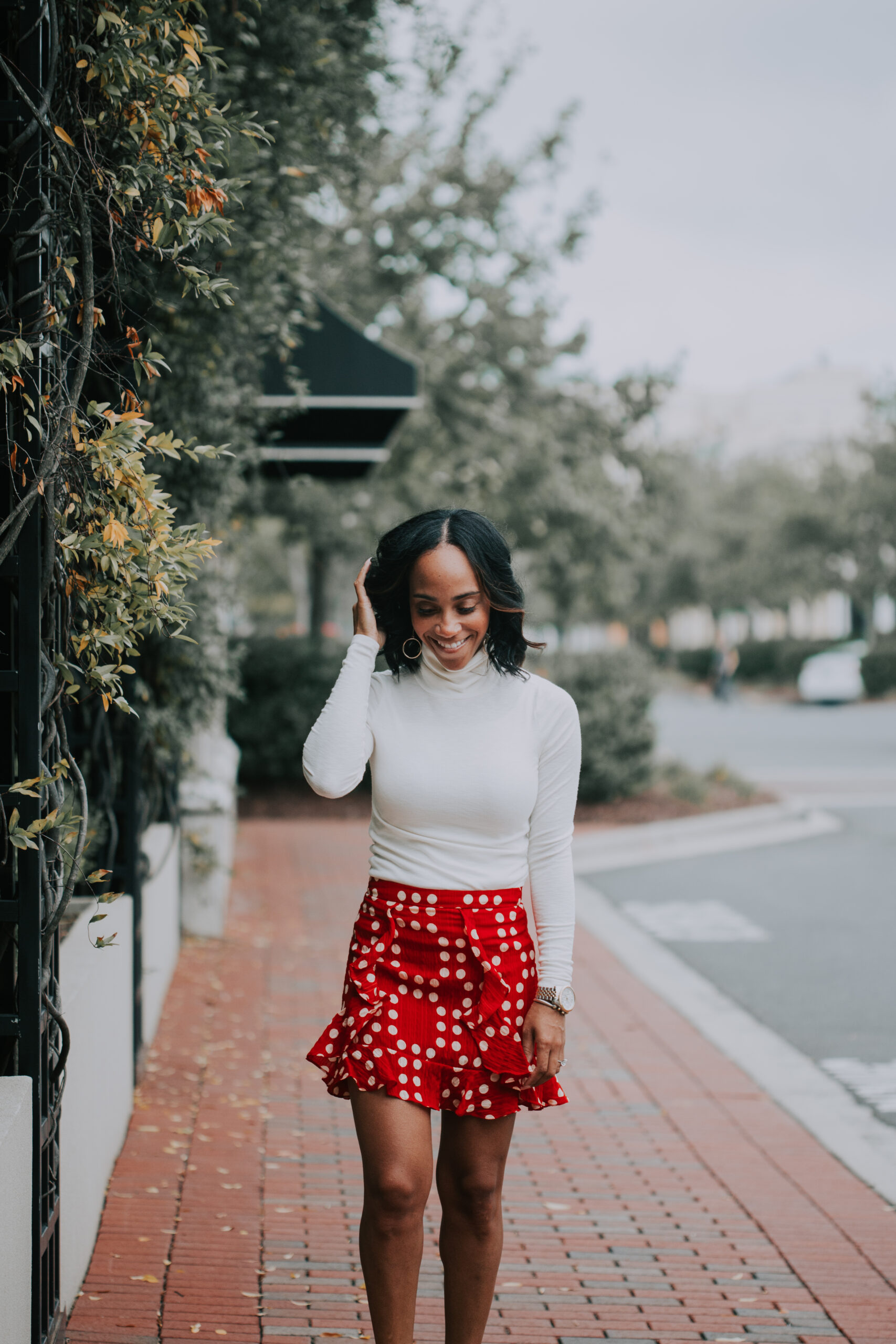 woman smiling and wearing white top and printed skirt on Southern Fall