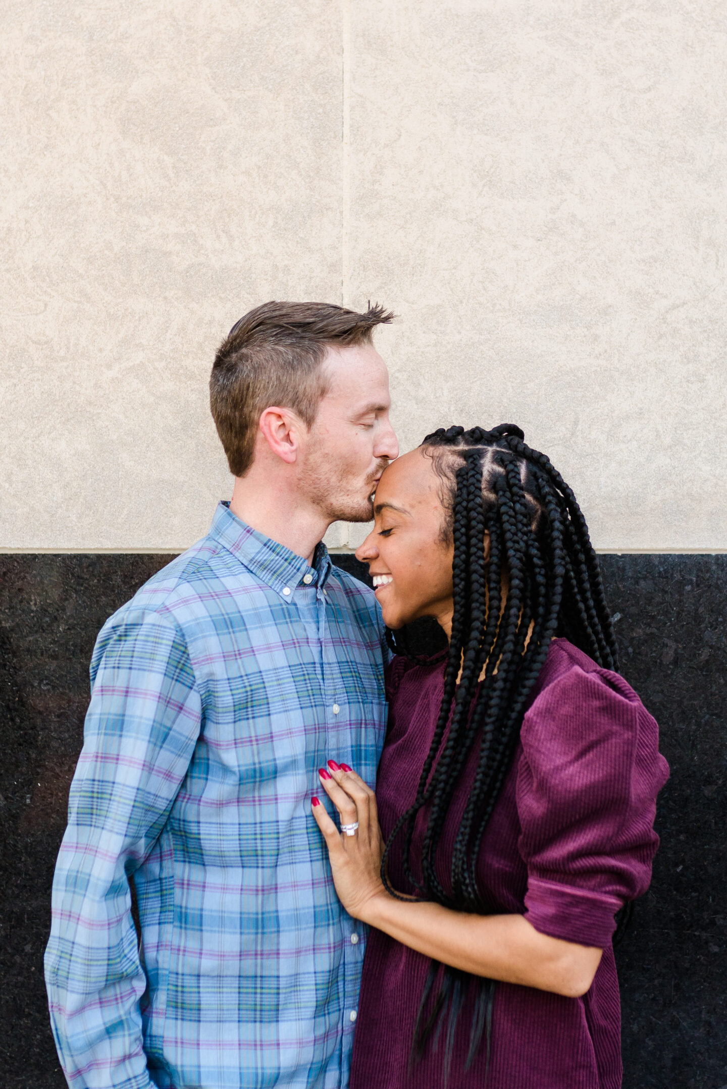 man kissing the forehead of a woman