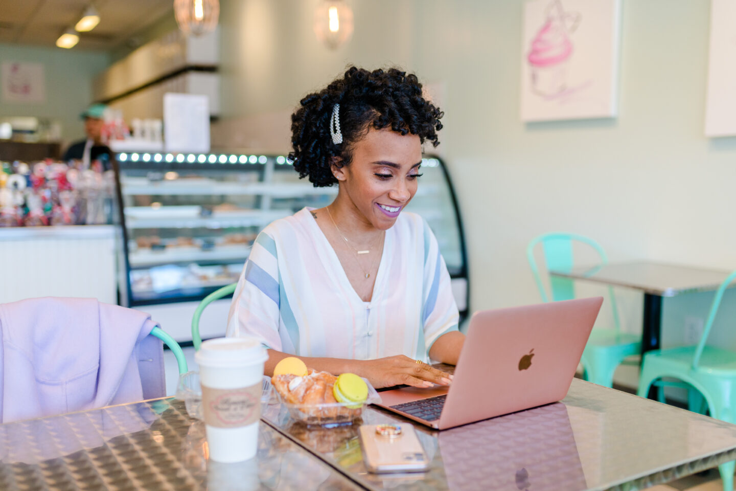 woman using her laptop in a cafe sharing Grow Your Blogs e-Subscription