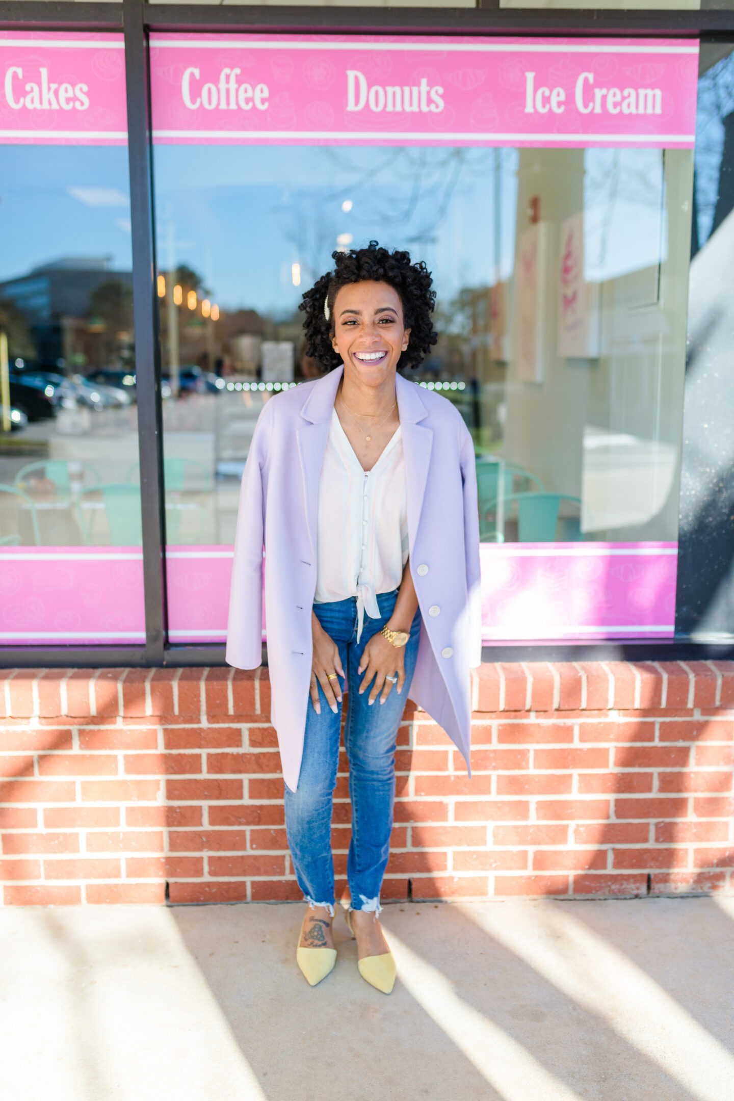 woman smiling and standing outside a cafe