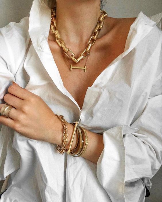 woman wearing white top with chunky necklace