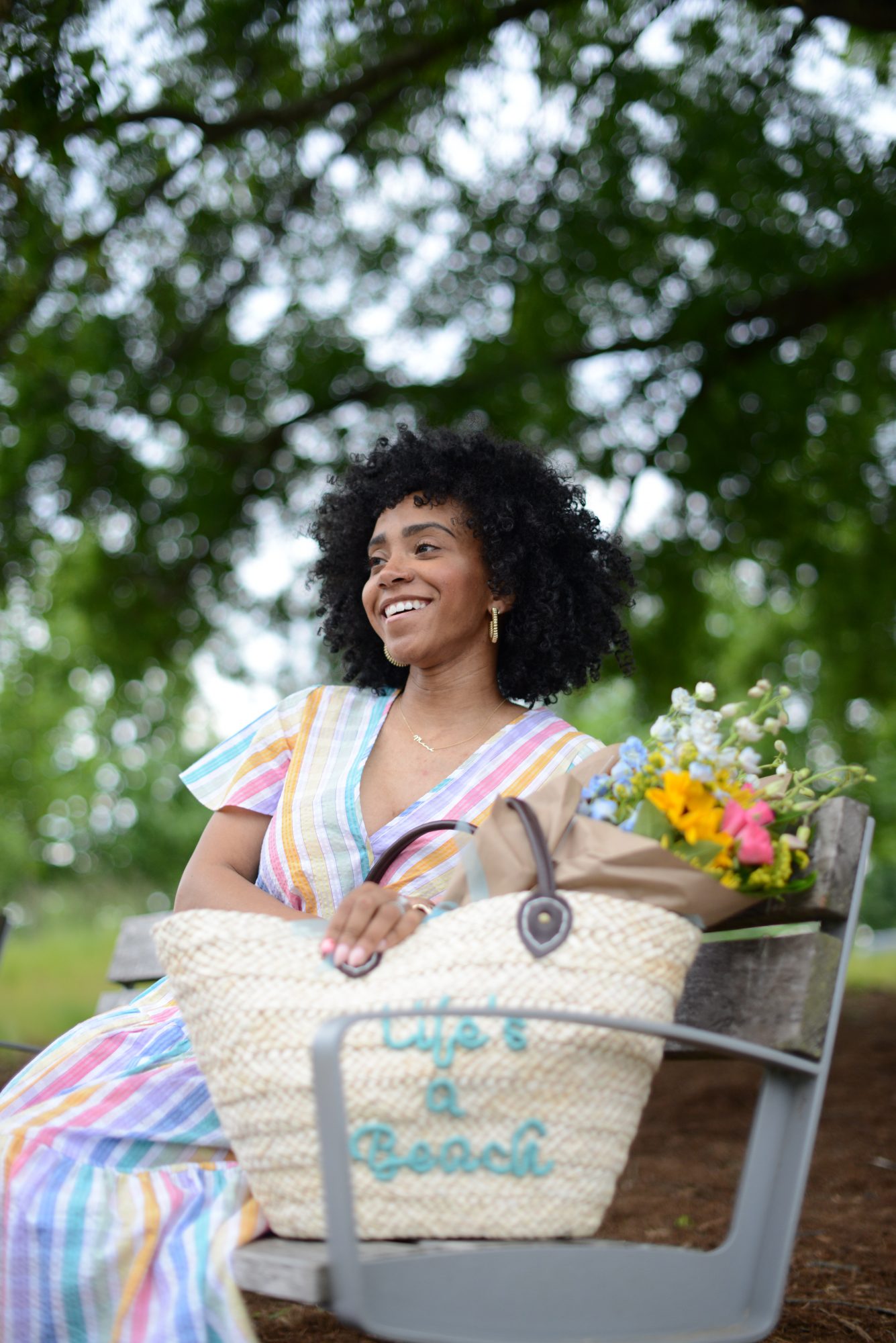 woman wearing colorful dress and sitting on a bench for Upgrade your Closet for Summer