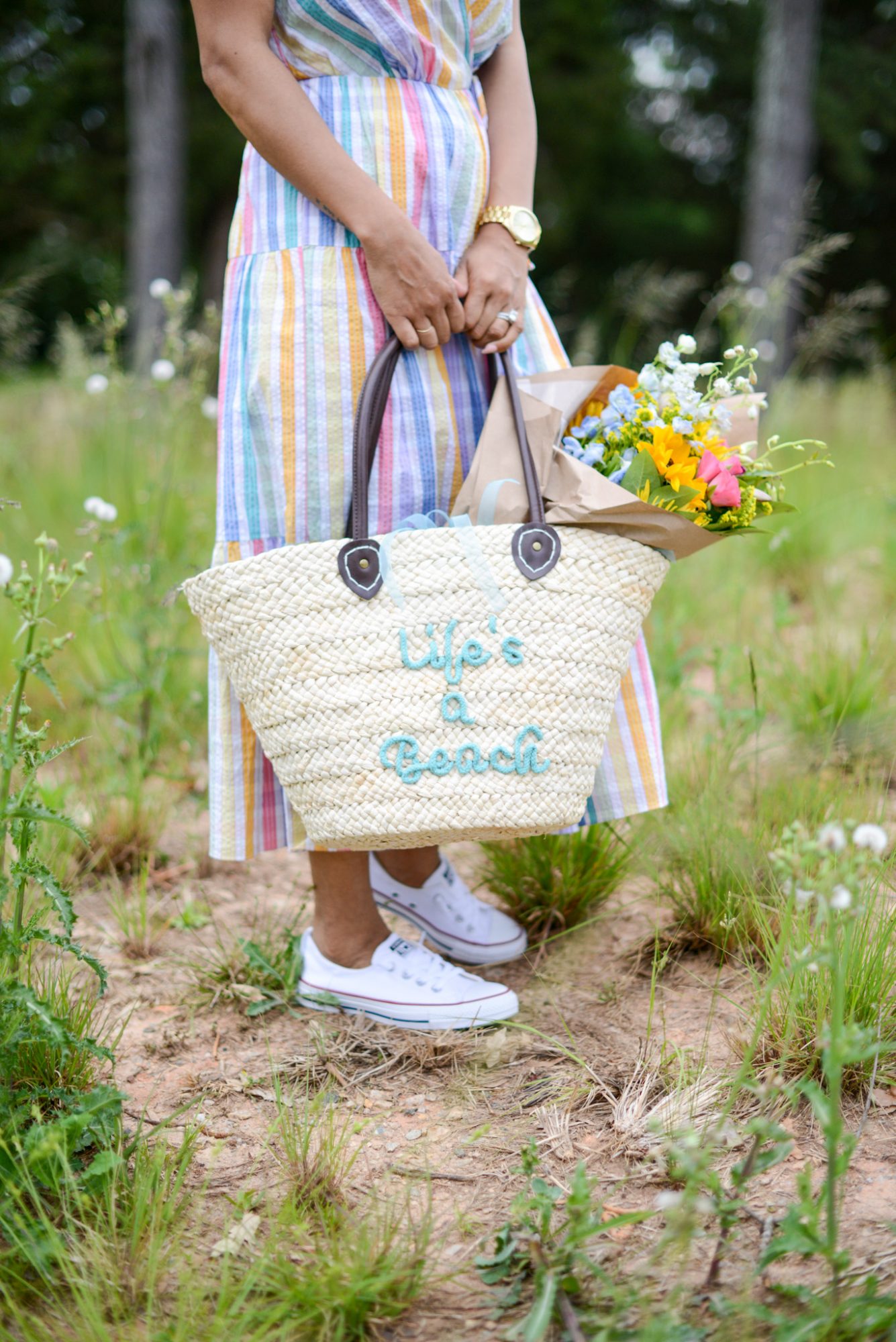 woman wearing colorful dress and holding a bag with flowers Upgrade your Closet for Summer