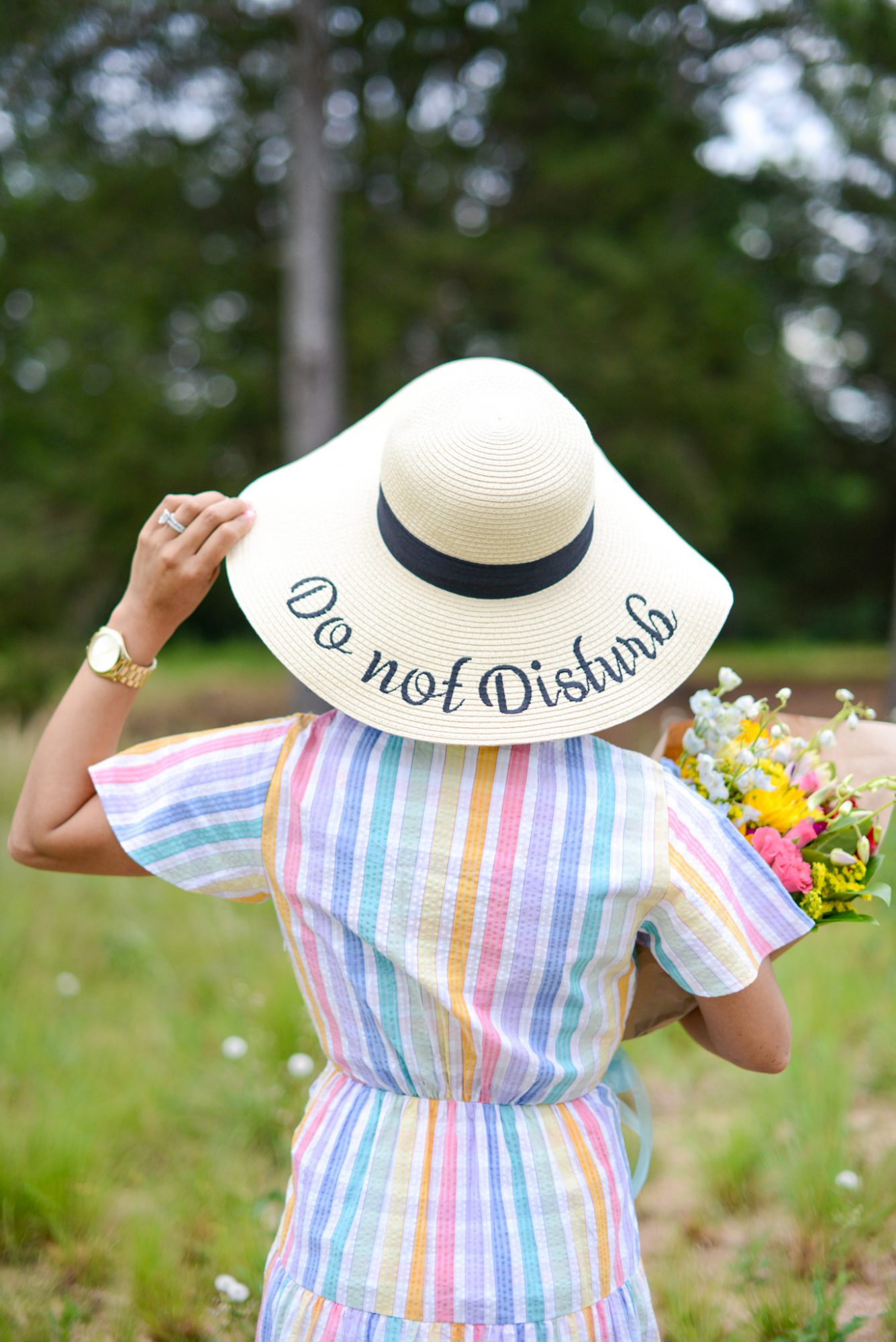 woman wearing a weaved hat with do not disturb text