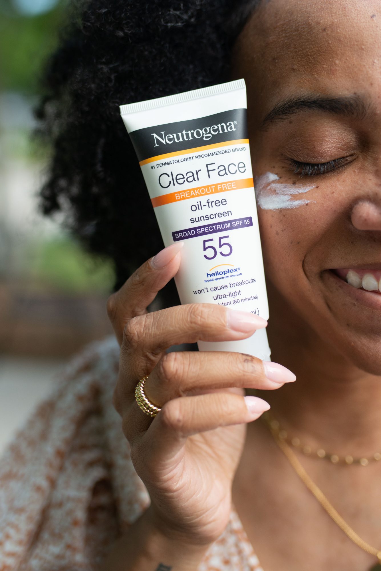 woman holding neutrogena showing how to Wear Sunscreen